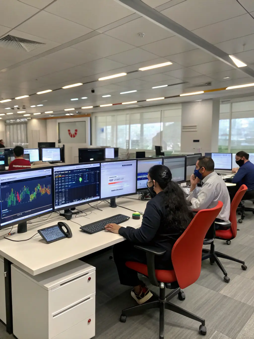 A modern office space with employees working on computers and collaborating, showcasing DataTel360.tech's IT services for office environments.